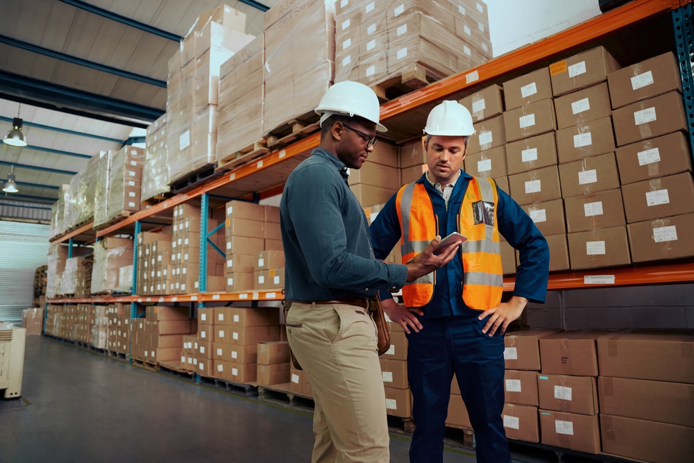 two warehouse managers looking at a wms tablet