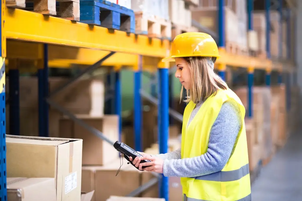 female worker using rugged mobile computer in warehouse