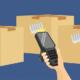 illustration of hand holding rugged barcode scanner near boxes